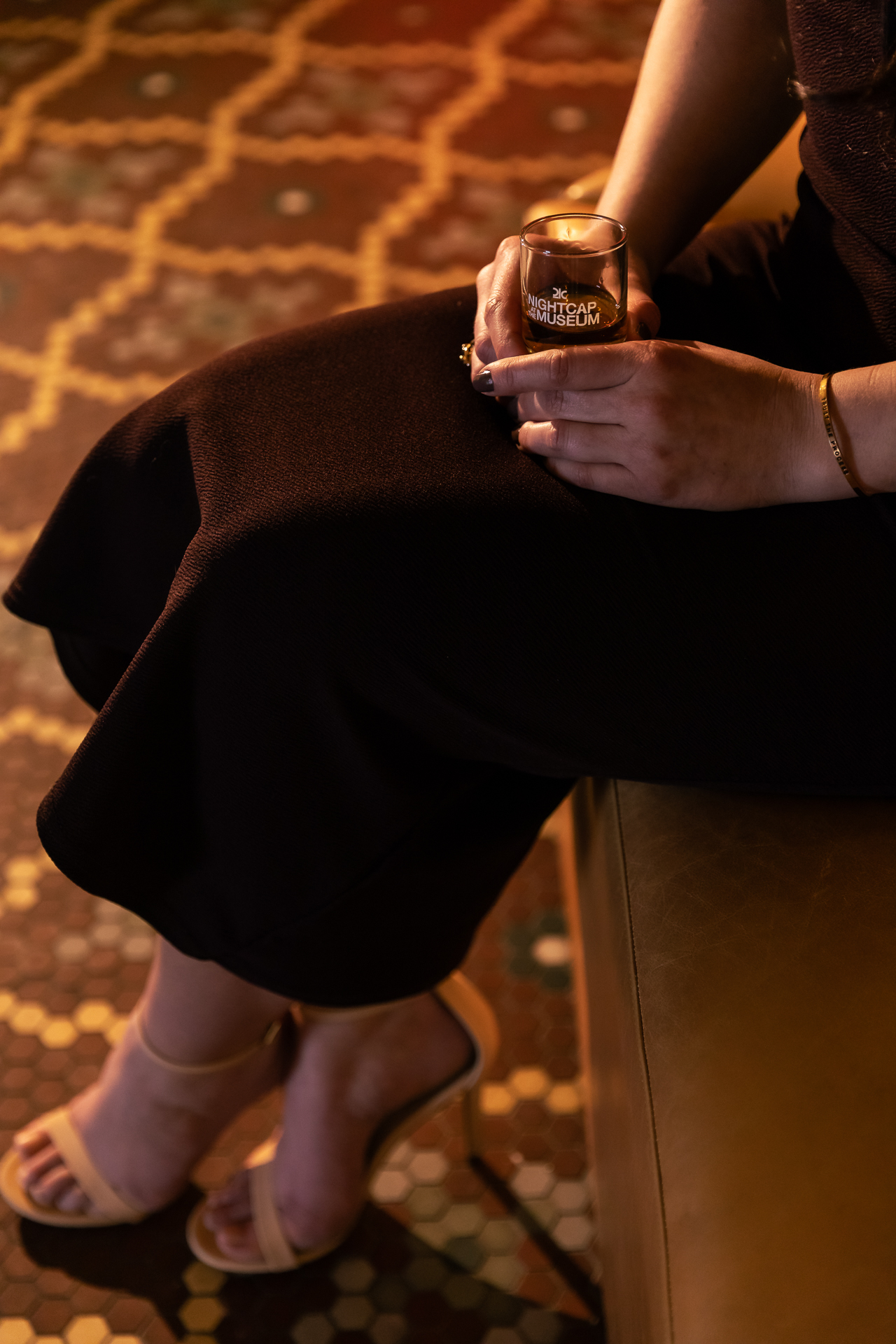 commercial photography at 21C museum hotel of a woman holding a drink with tile floor behind her