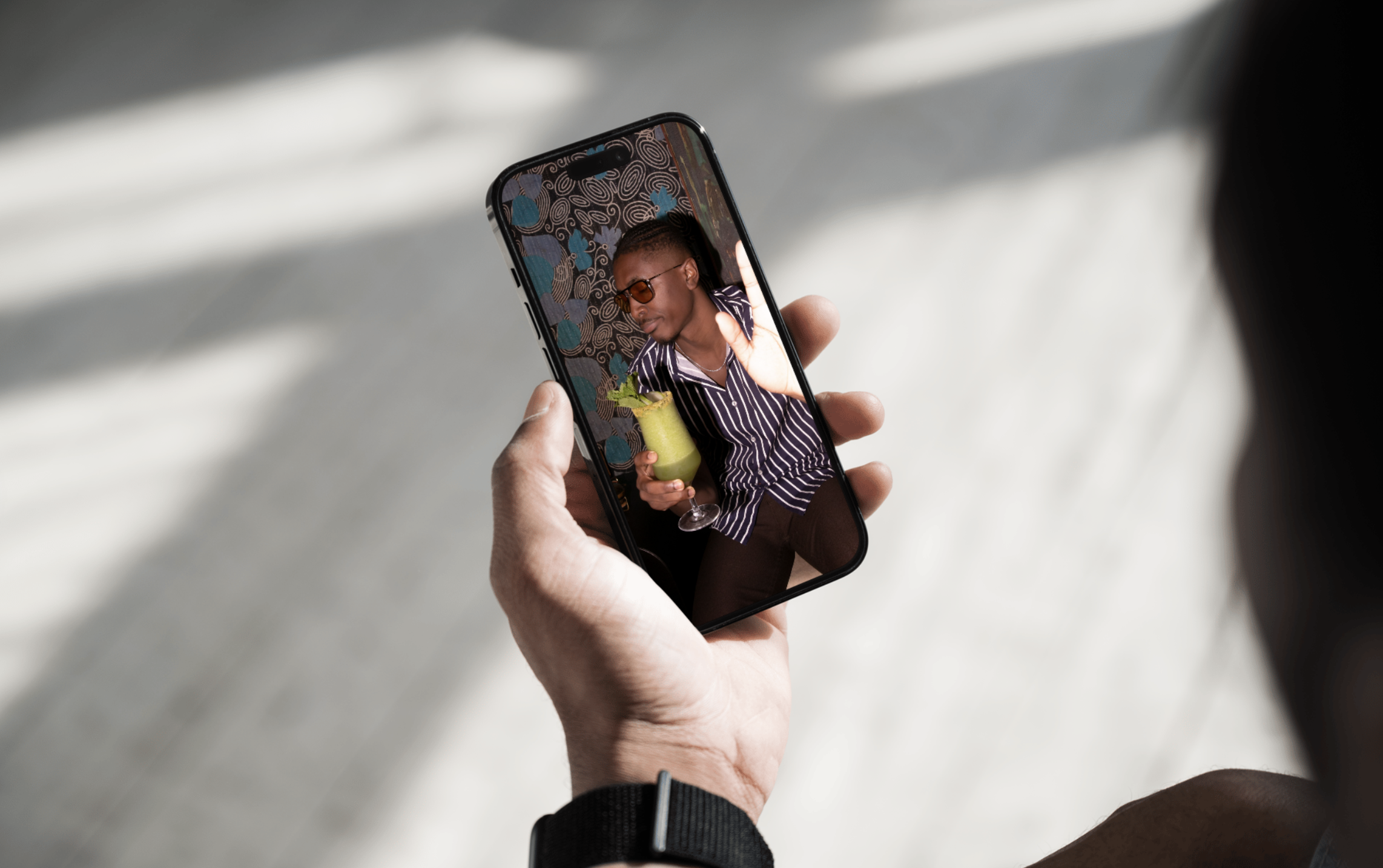 someone holding a phone viewing an image of someone holding a drink