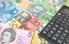 A calculator sitting on top of a pile of money.