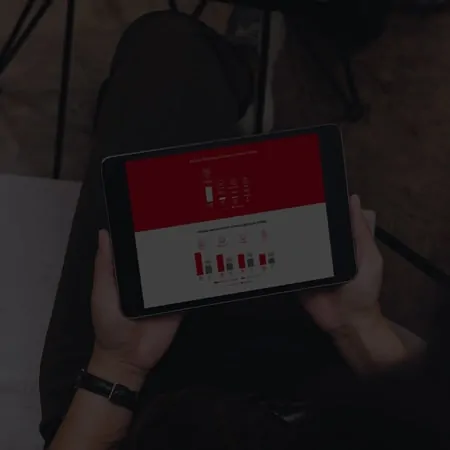 A person holding a tablet with a bar chart on the screen.