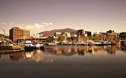 A harbour filled with lots of boats next to tall buildings.