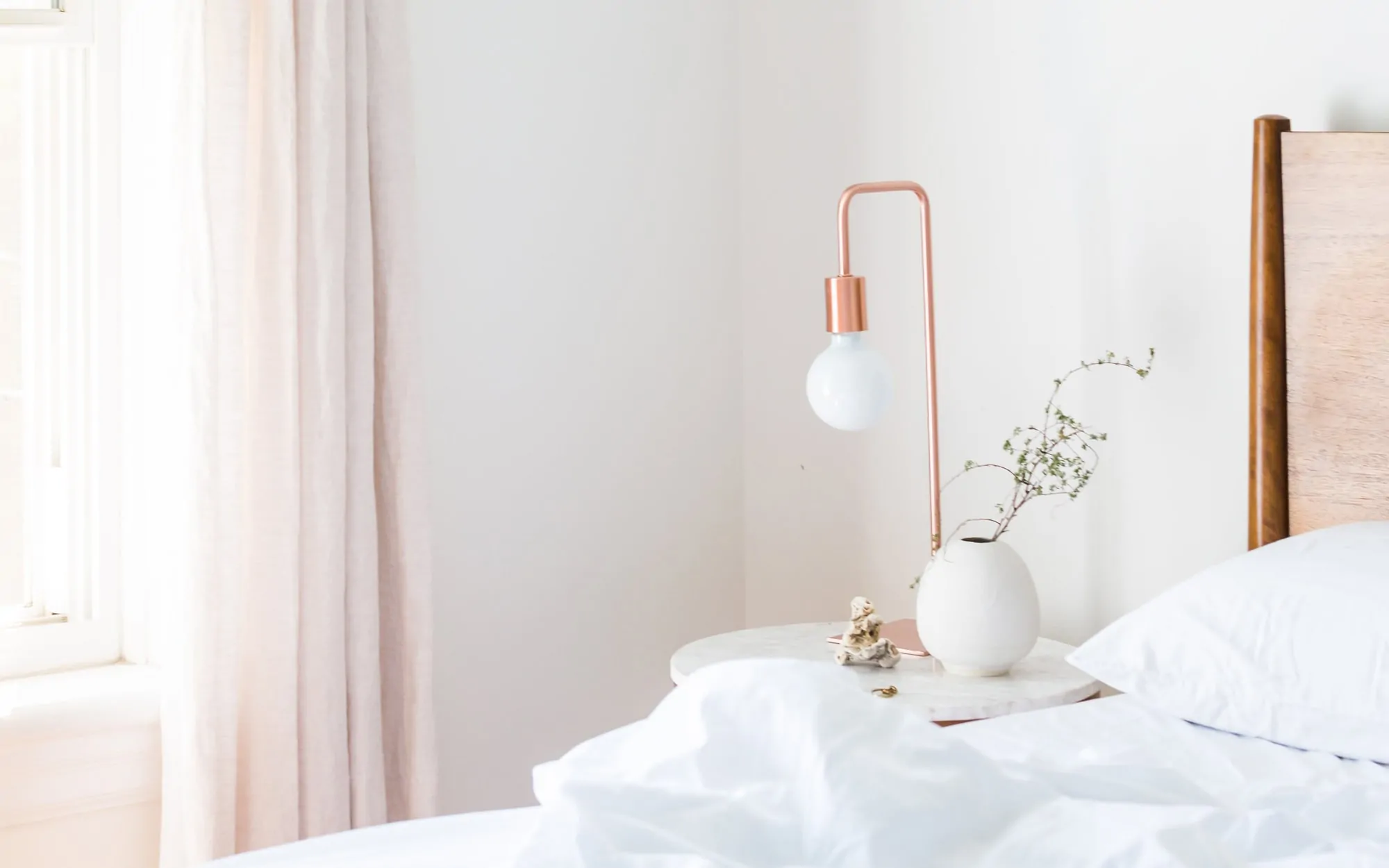 A bed with a white comforter and a wooden headboard.