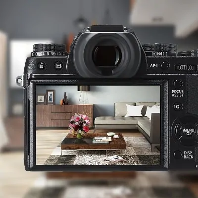 A digital camera with a living room in the background.