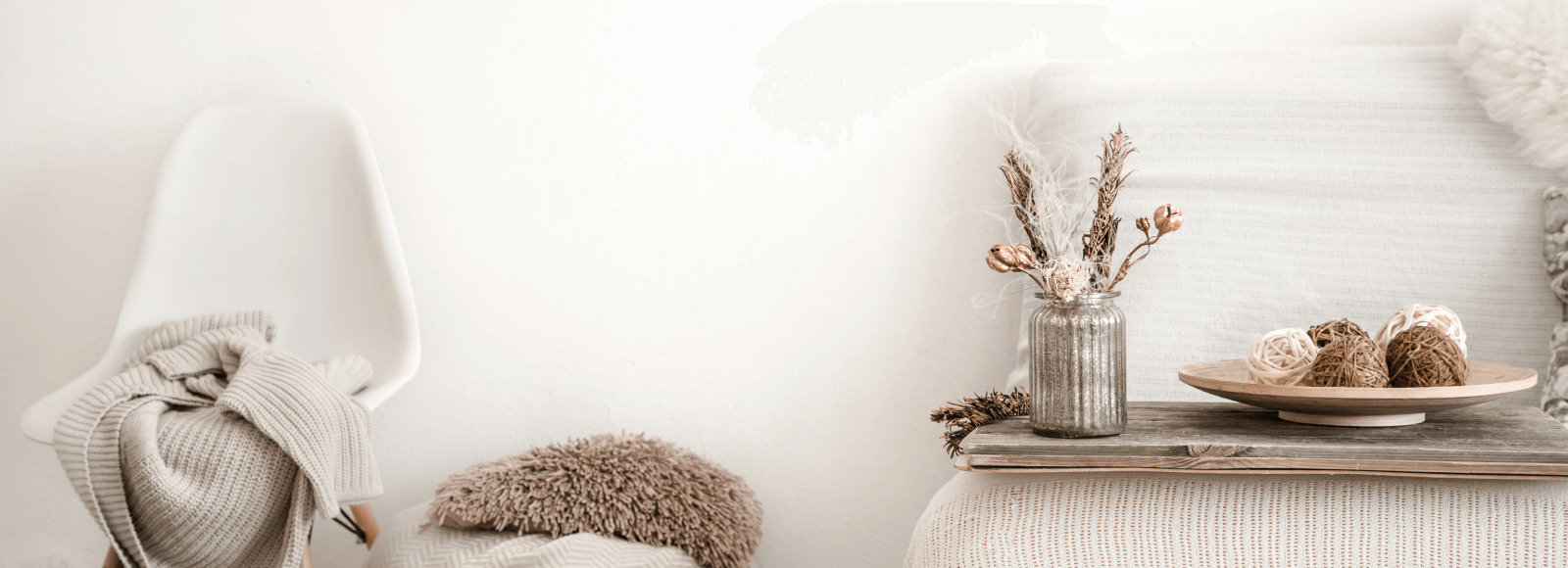 A table with a plate of decor and a vase of flowers.
