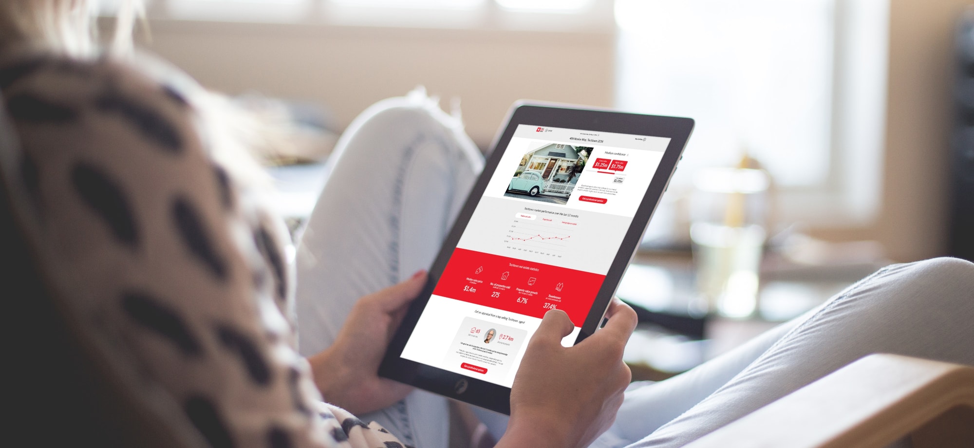 A person sitting on a couch holding a tablet.