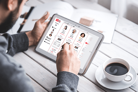A man sitting at a table using a tablet.