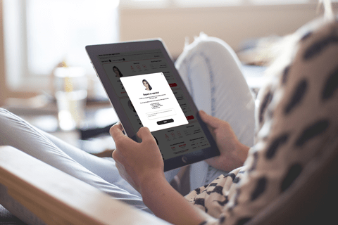 A person sitting in a chair holding a tablet.