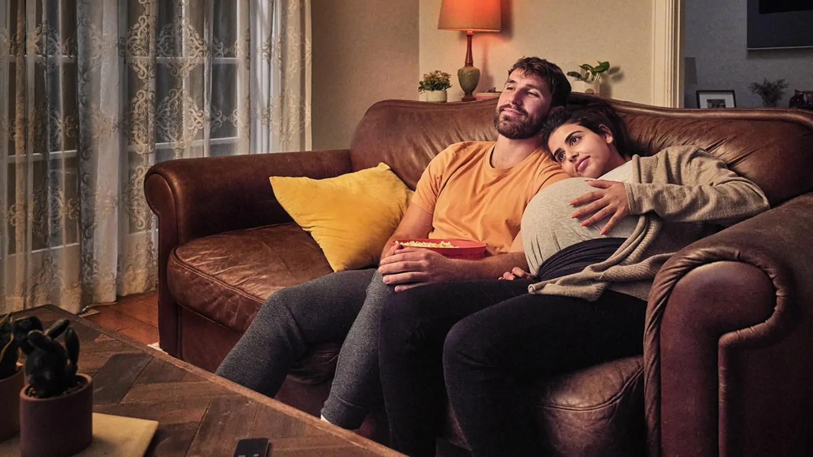 A man and a woman sitting on a couch.
