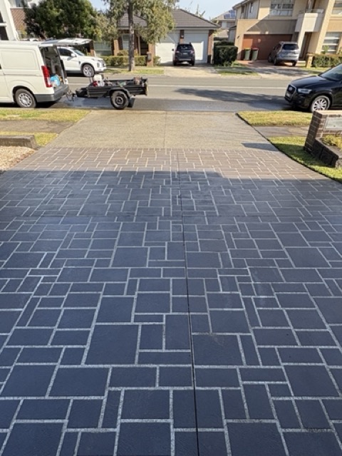 Freshly cleaned patterned driveway in a suburban front yard
