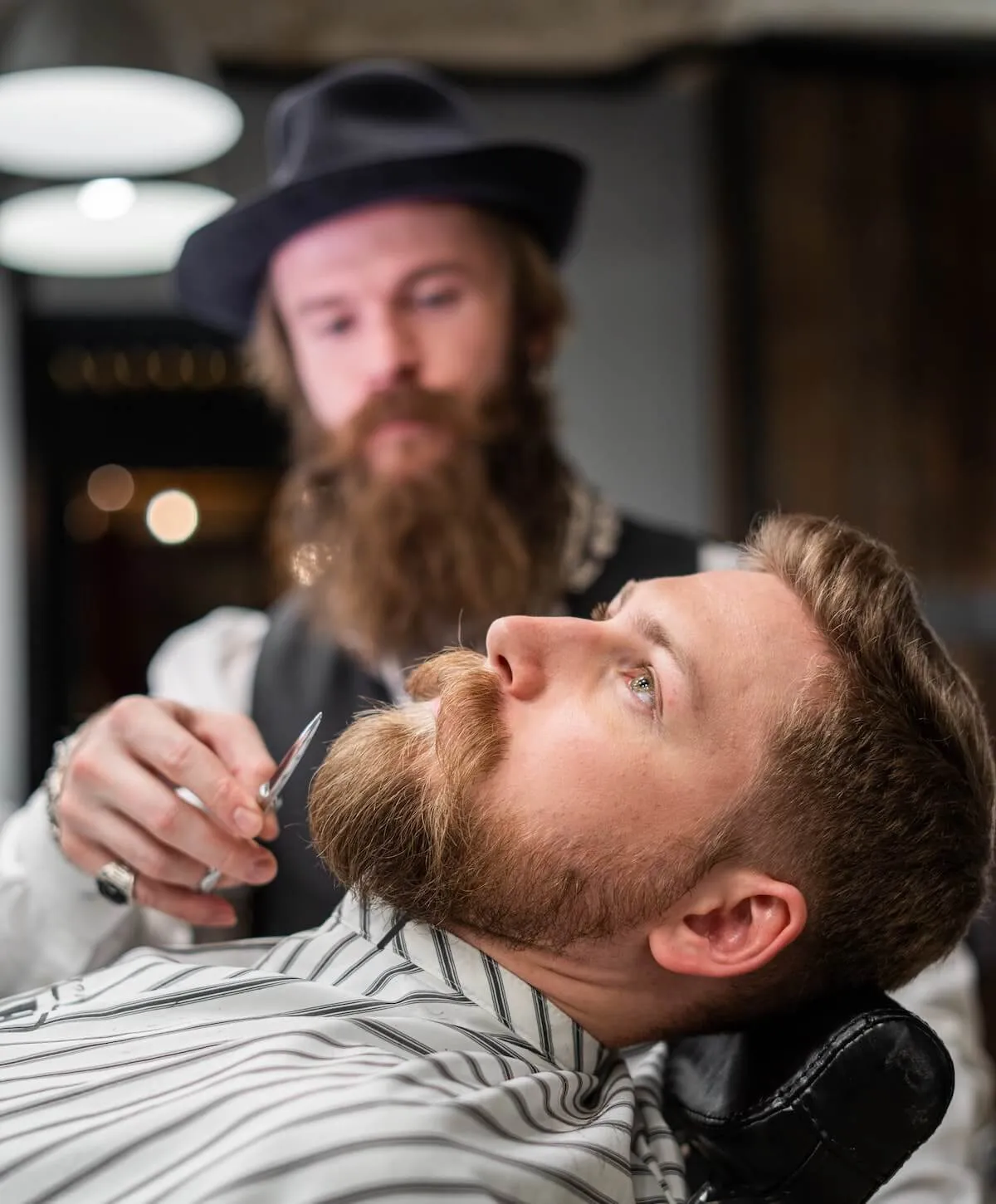 Barber with a new business serving his customer with a beard trim