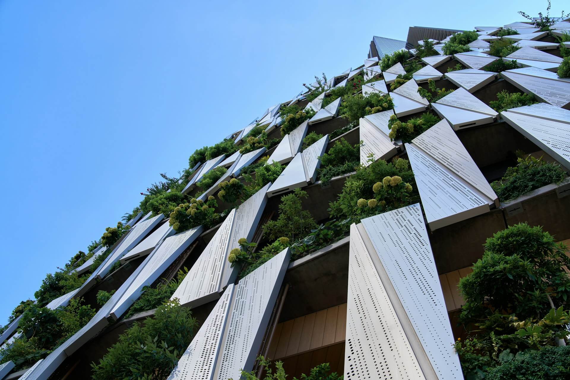 a very tall building with a bunch of plants growing on it