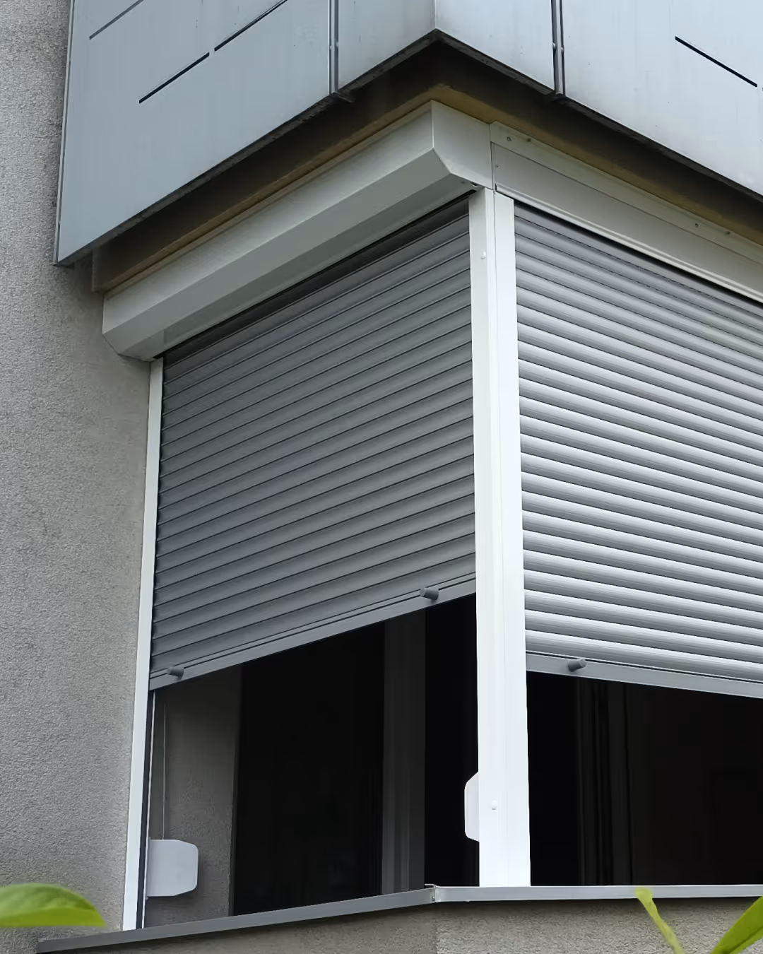 Vanjski kutni prozor s metalnim roletama na stambenoj zgradi.