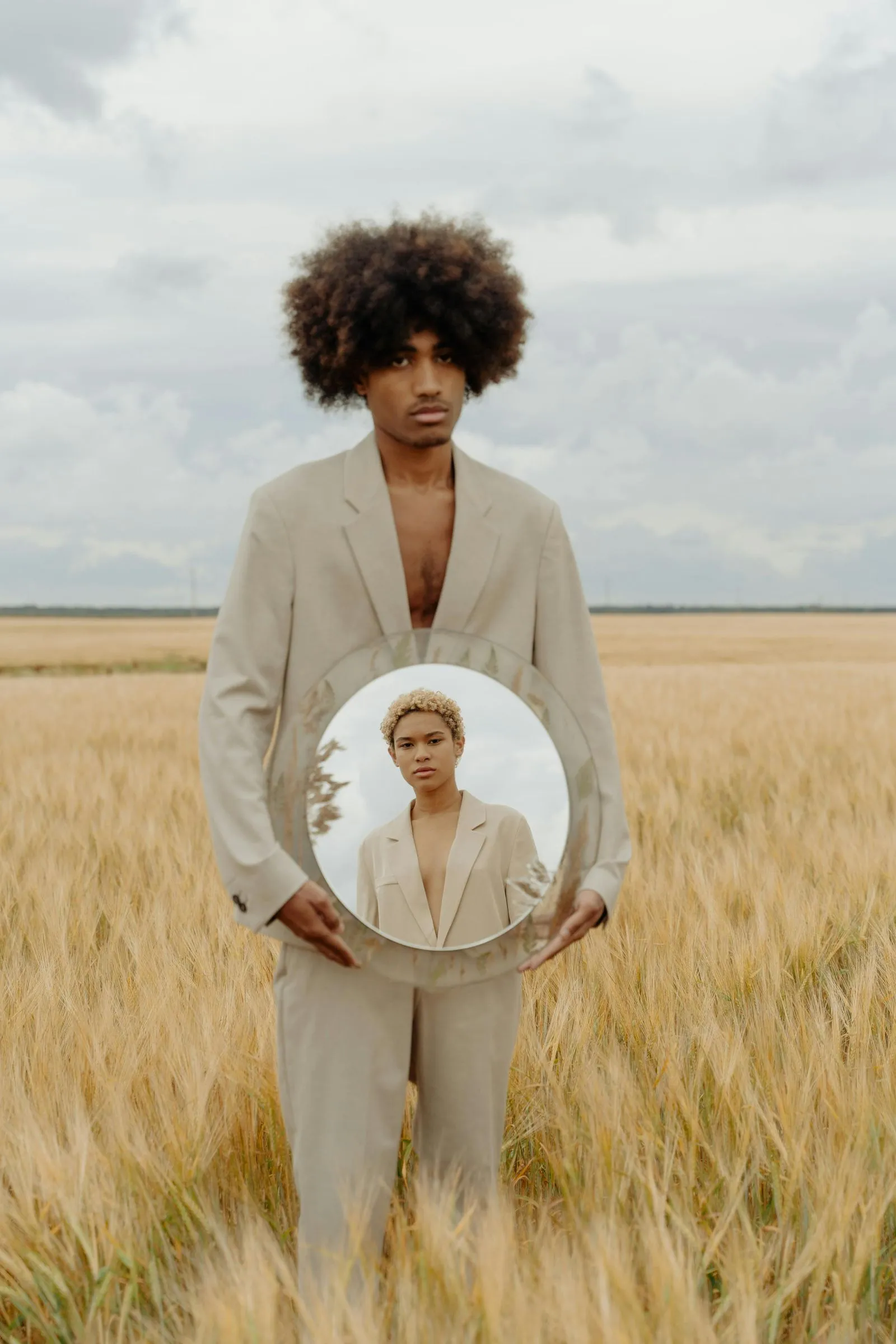 Man holding a mirror in a field