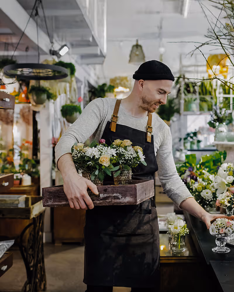 Florist arranging bouquets in a shop, reflecting personalized digital retail and eCommerce optimization