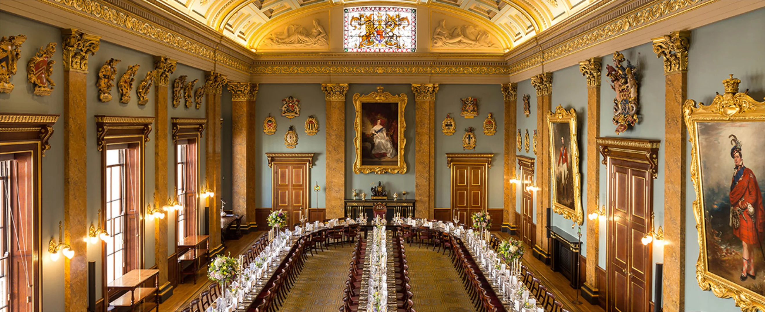 A luxury dining hall with gold furnishings and artwork.