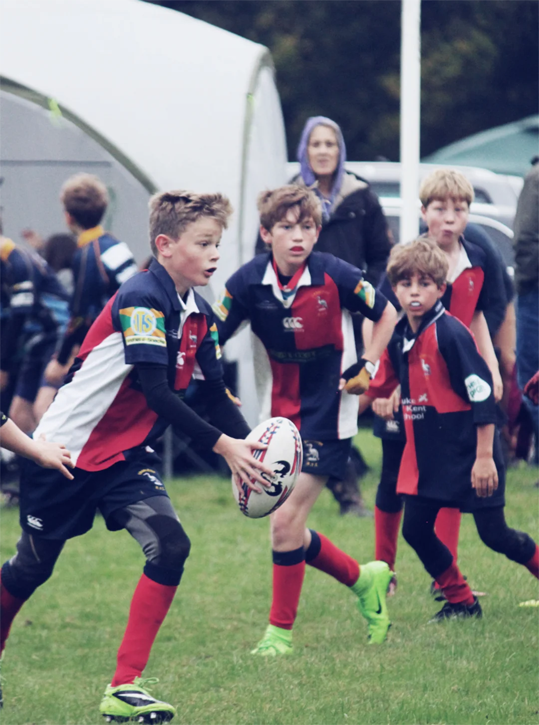 Youth rugby players playing rugby for Cranleigh rugby club in white red and blue kit.
