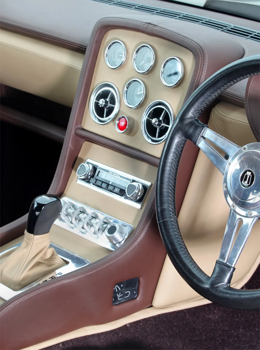 Interior of a luxury British classic car in tan and brown.