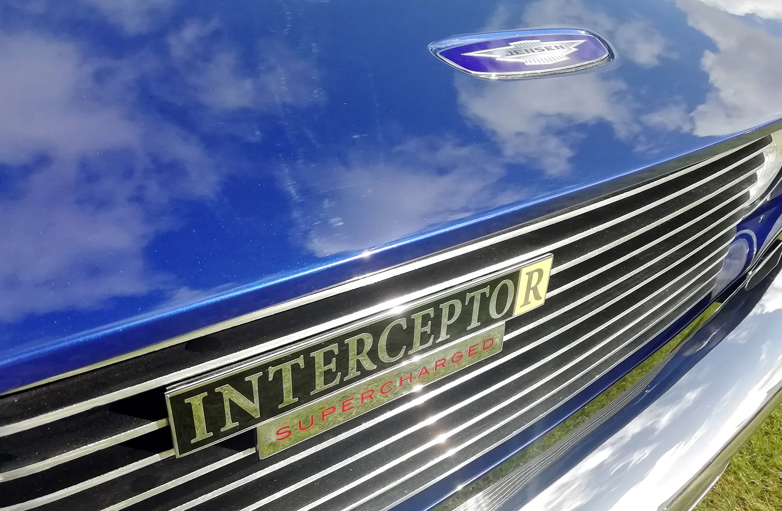 Closeup photograph of a luxury British classic car in blue and chrome.