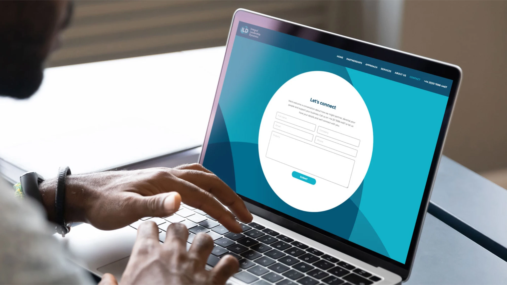 Person using a laptop with the ILD website on a contact/sign in form in blue and white.