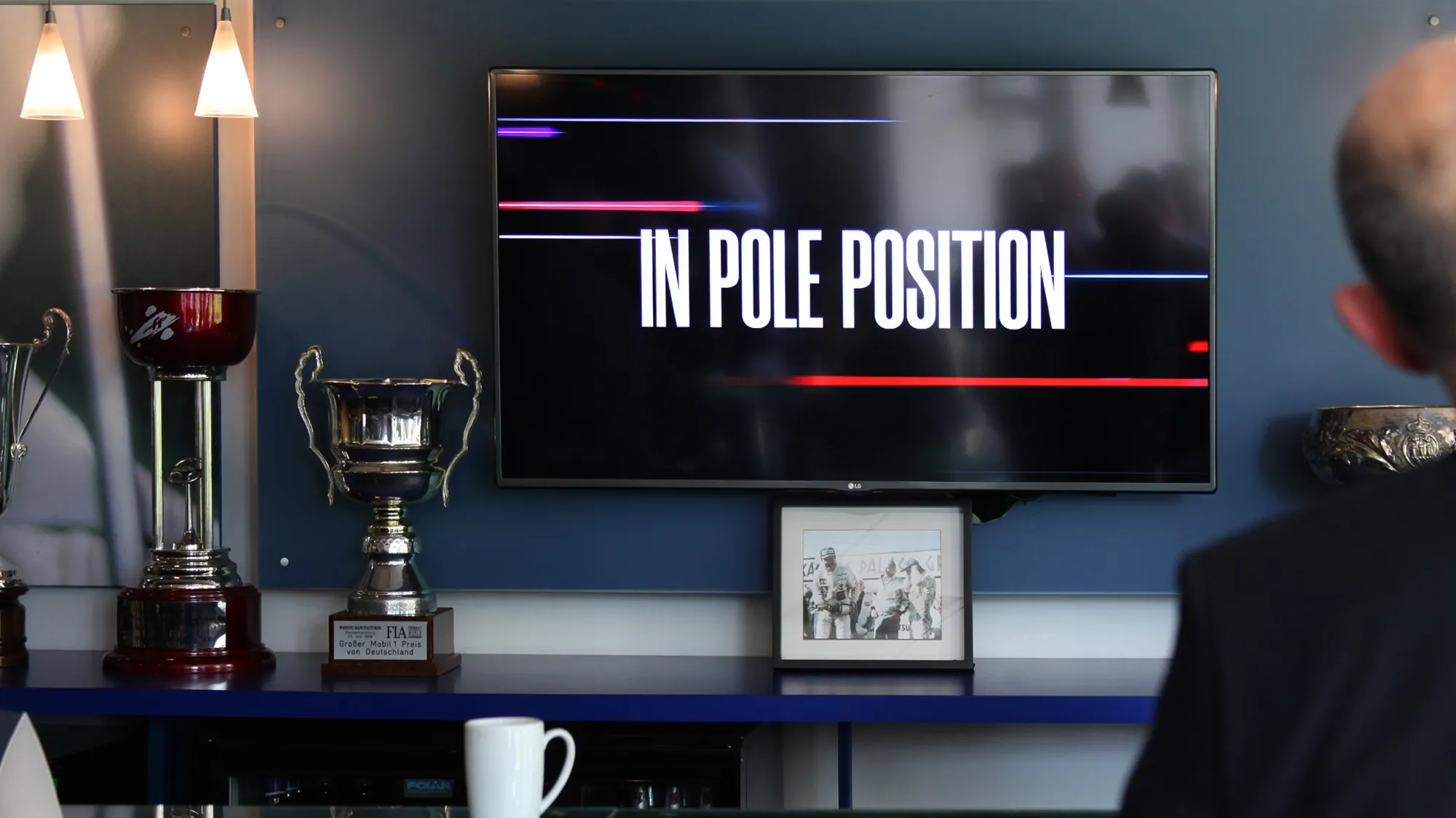 A room with trophies around and a television with the IBMG Pole Position branding displayed.