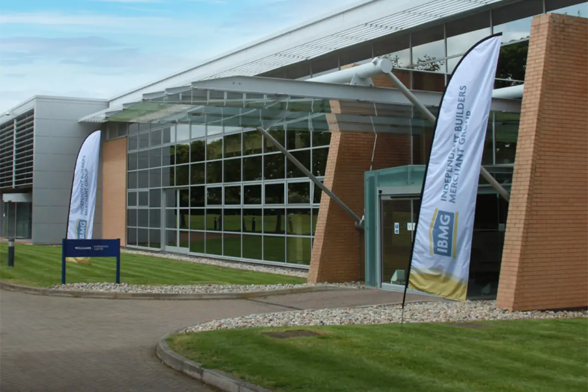 Large office building with IBMG branded flag banners outside.