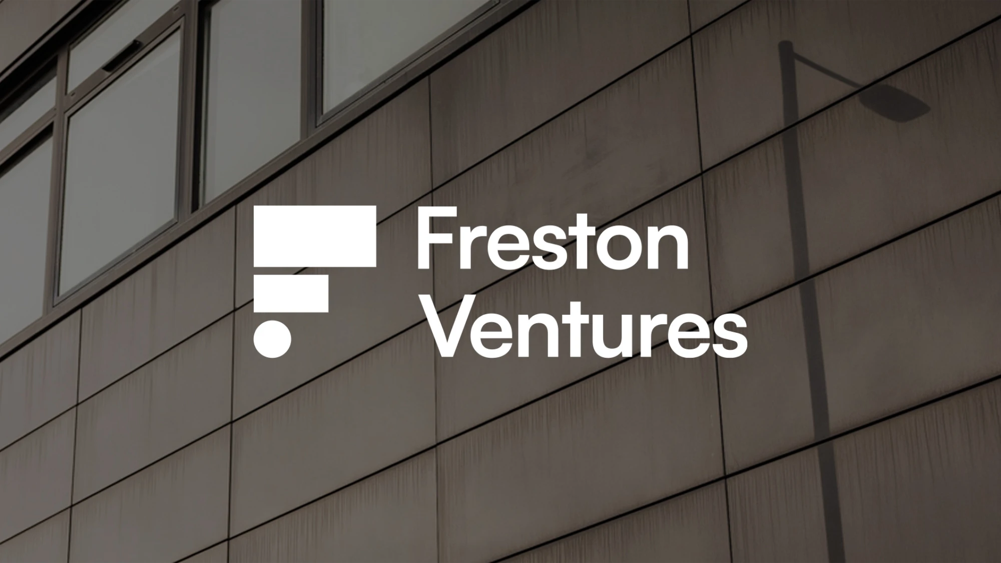 Freston Ventures logo on white overlaying an image of a dark concrete building.