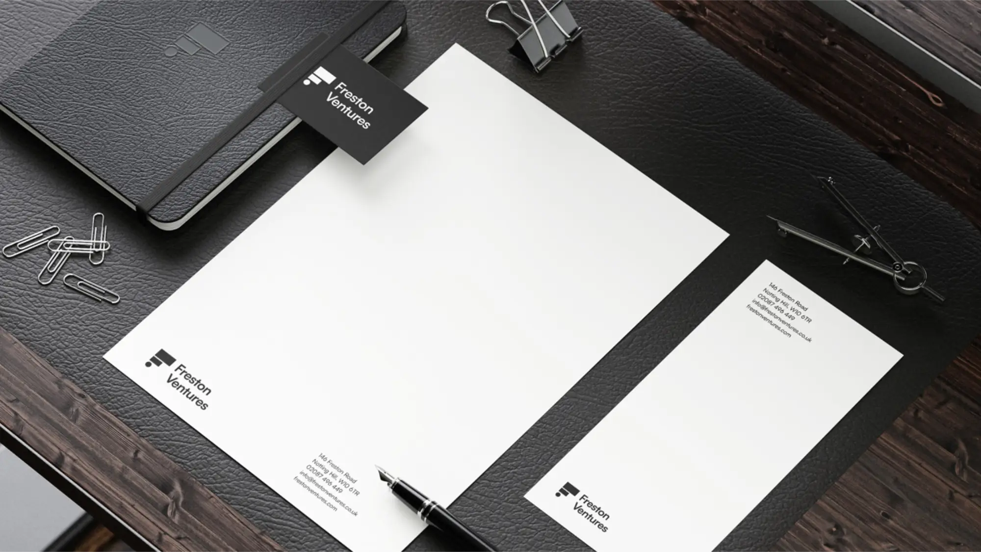 Freston Ventures branded headed paper and business cards on a dark wooden tabletop.