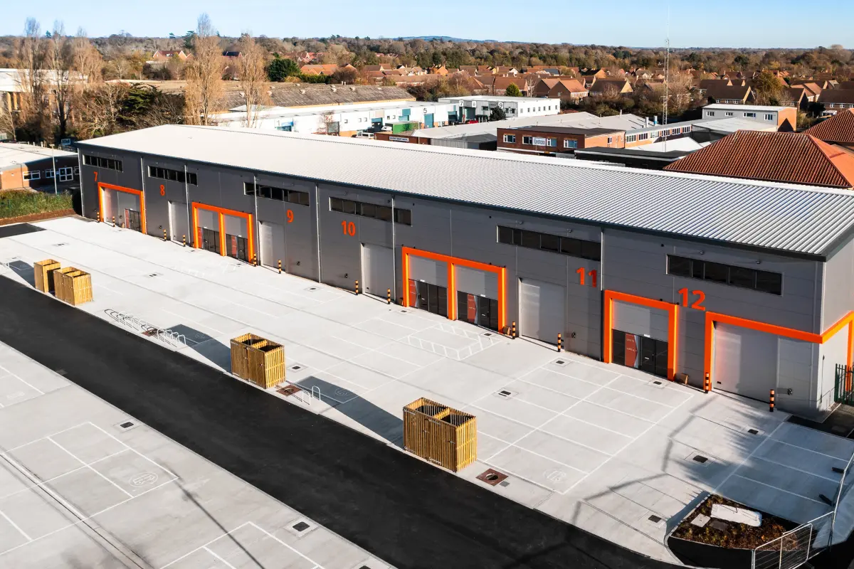 Aerial view of a modern industrial warehouse complex with numbered loading bays from 7 to 12 and surrounding paved area.