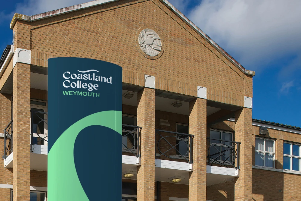 Building with a Coastland College banner out the front of it in blue and green.