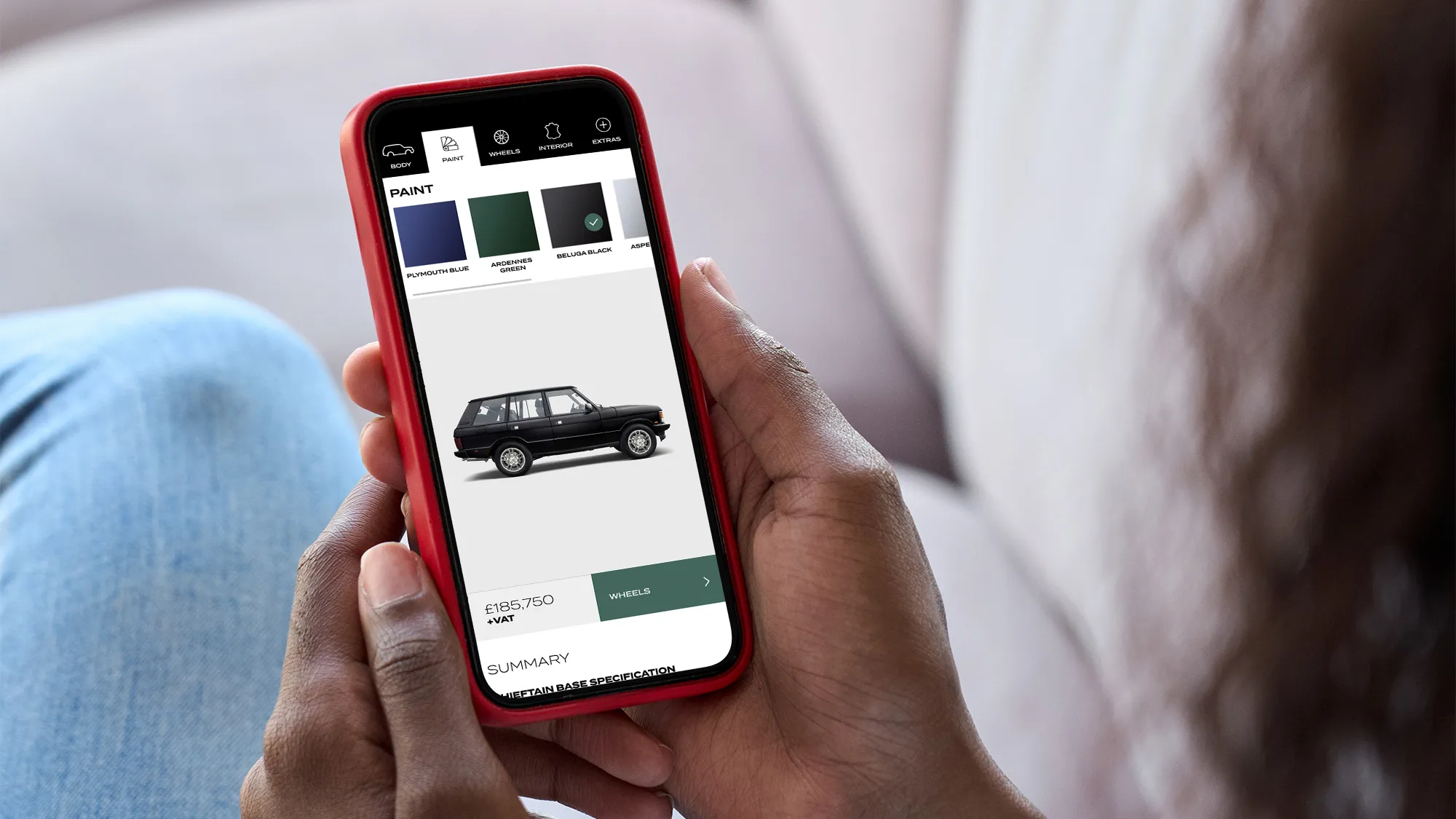 Woman using the Chieftain website on a phone looking to buy a range rover.