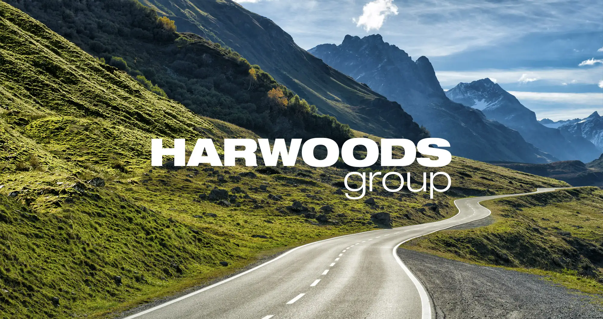 A road leading into the mountain with the Harwoods logo on it.