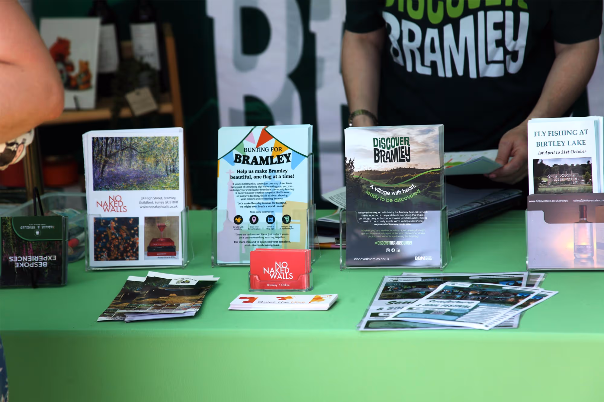 Table with brochures and flyers promoting Bramley including bunting, fly fishing at Birtley Lake, and local events.