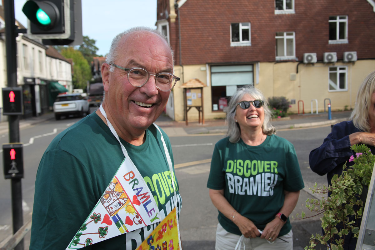 Two people in green Discover Bramley t shirts smiling with some customised bunting around them.