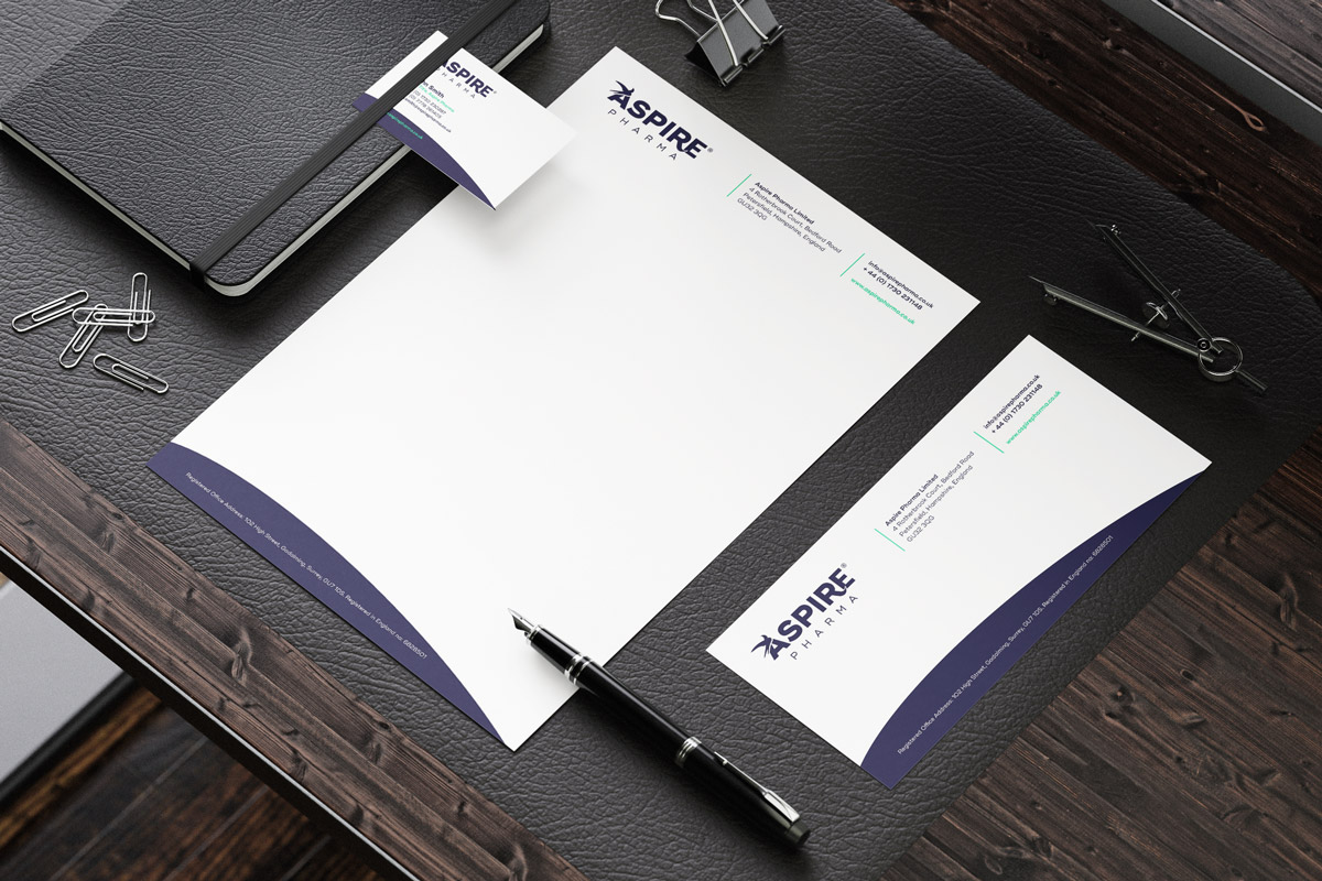 A stationary set with headed paper, and envelope and a business card with the Aspire Pharma branding.