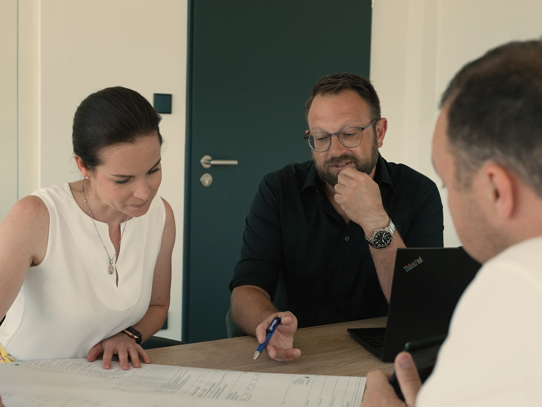 Drei Personen bei einem strategischen Gespräch – symbolisiert Synergien, Zusammenarbeit und Gruppenstärke bei Instaltec