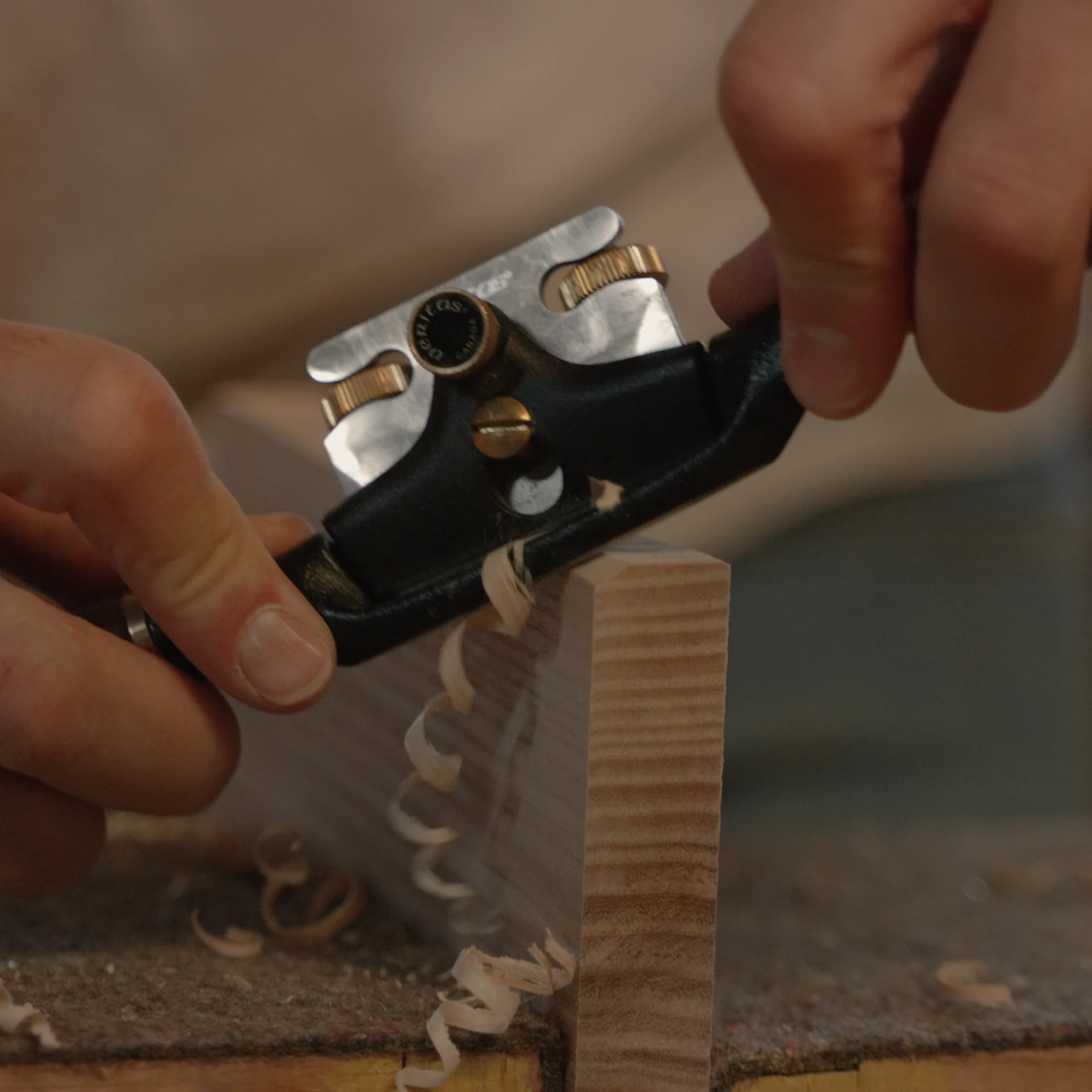 Handhobel bei der Bearbeitung eines Holzstücks – traditionelles Handwerk