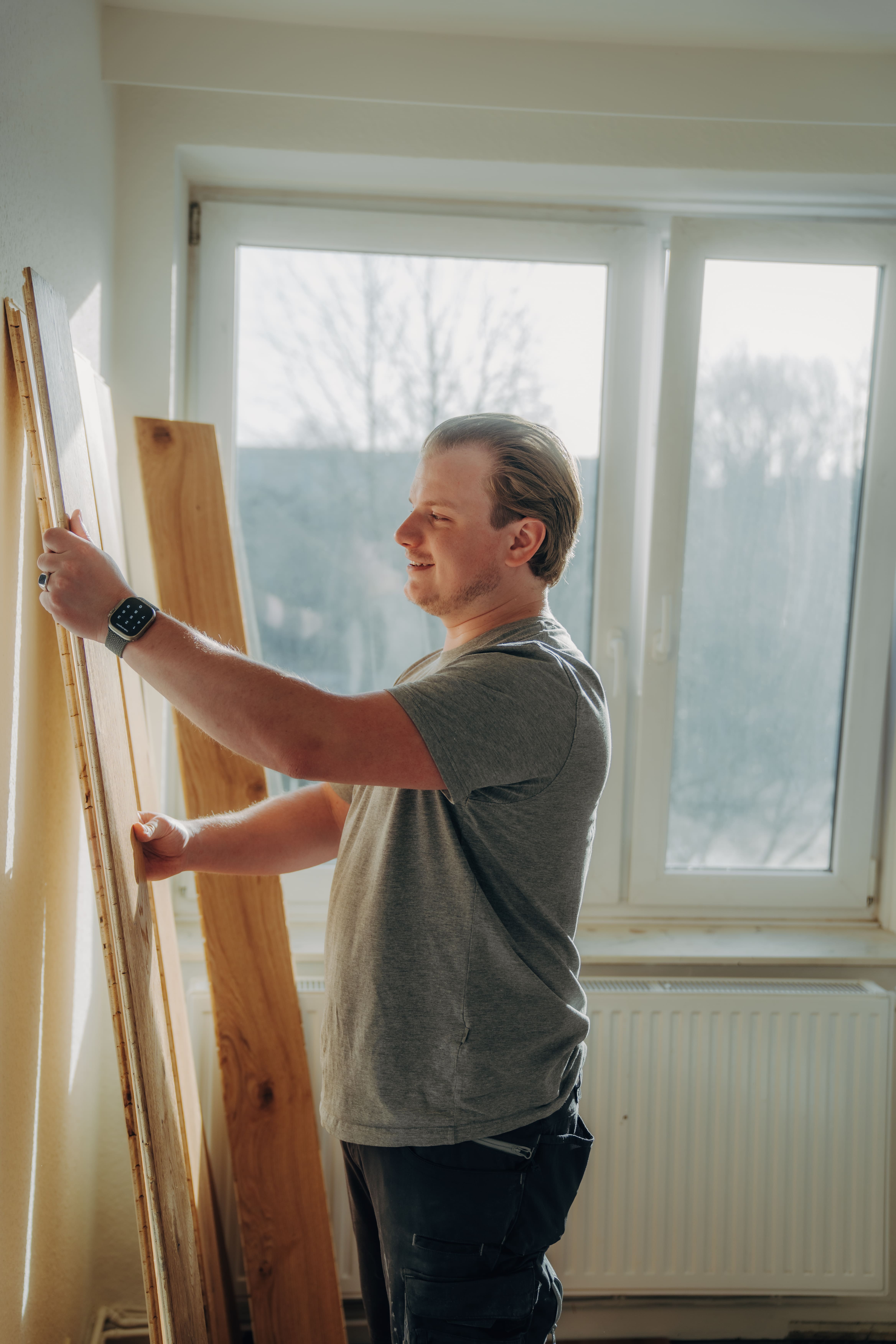 Handwerker hält Parkett | Professionelle Bodenverlegung von Bodenschmiede
