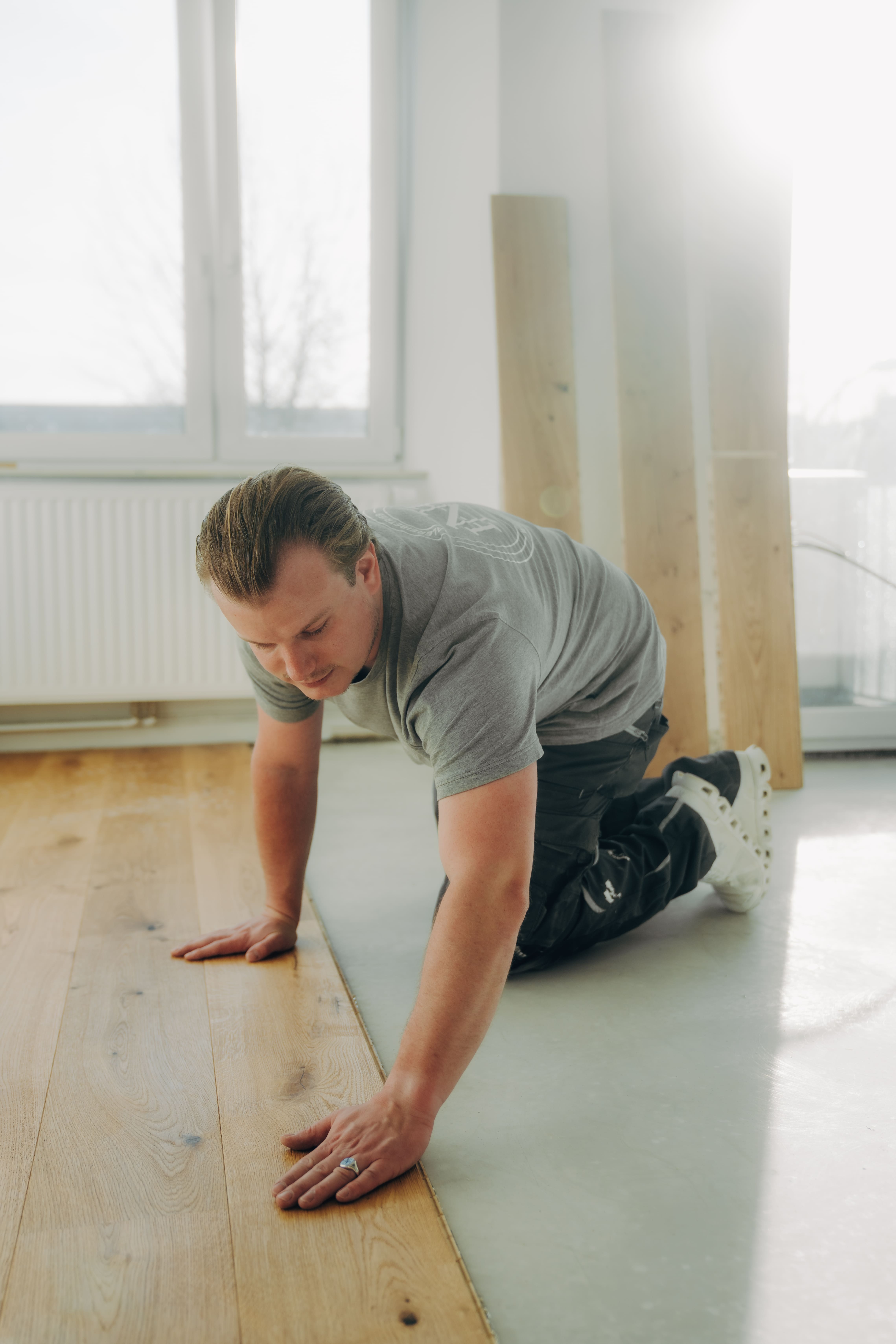 Handwerker verlegt Holzboden | Professionelle Bodenverlegung in Hamburg