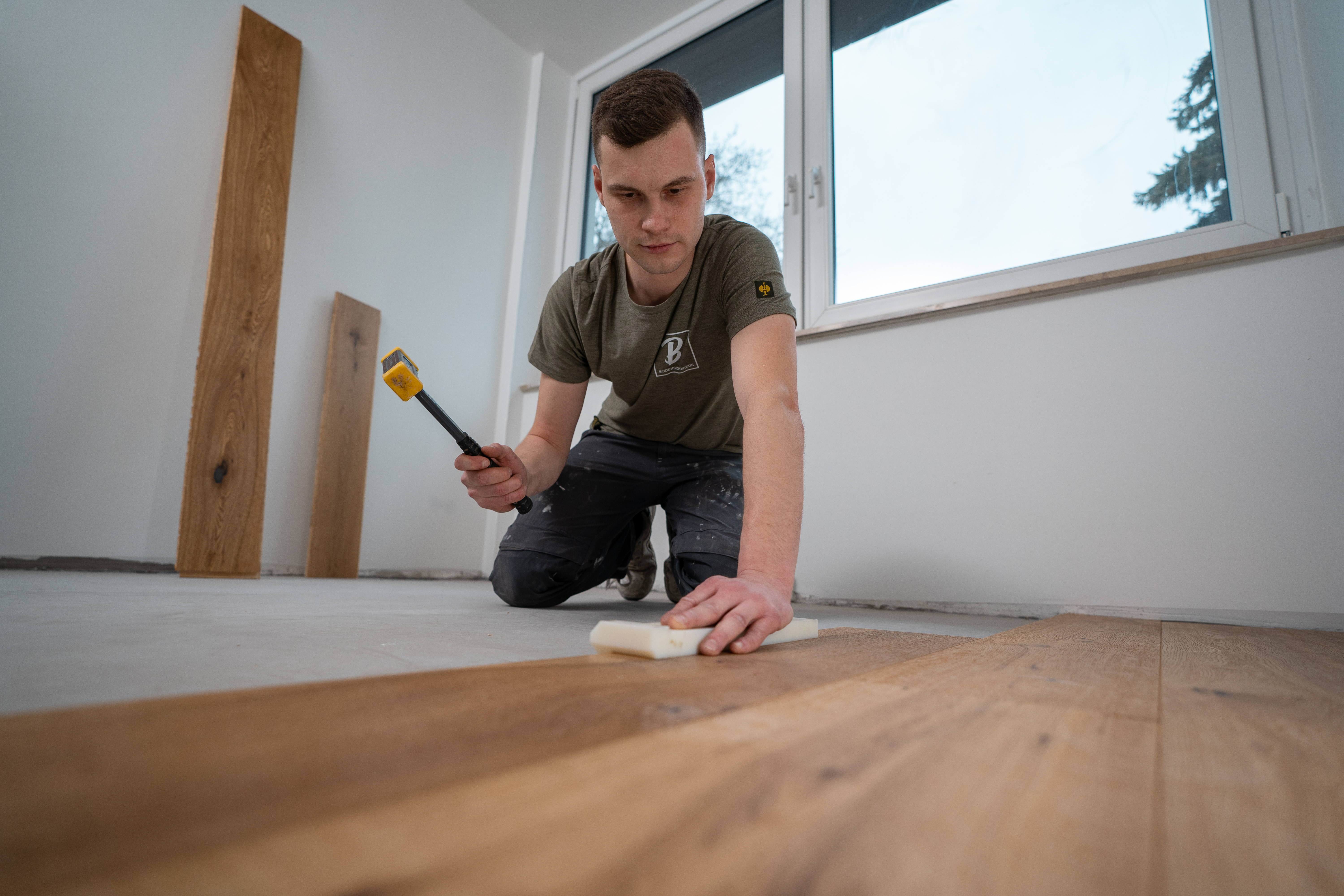 Handwerker verlegt Holzboden | Professionelle Bodenverlegung in Hamburg