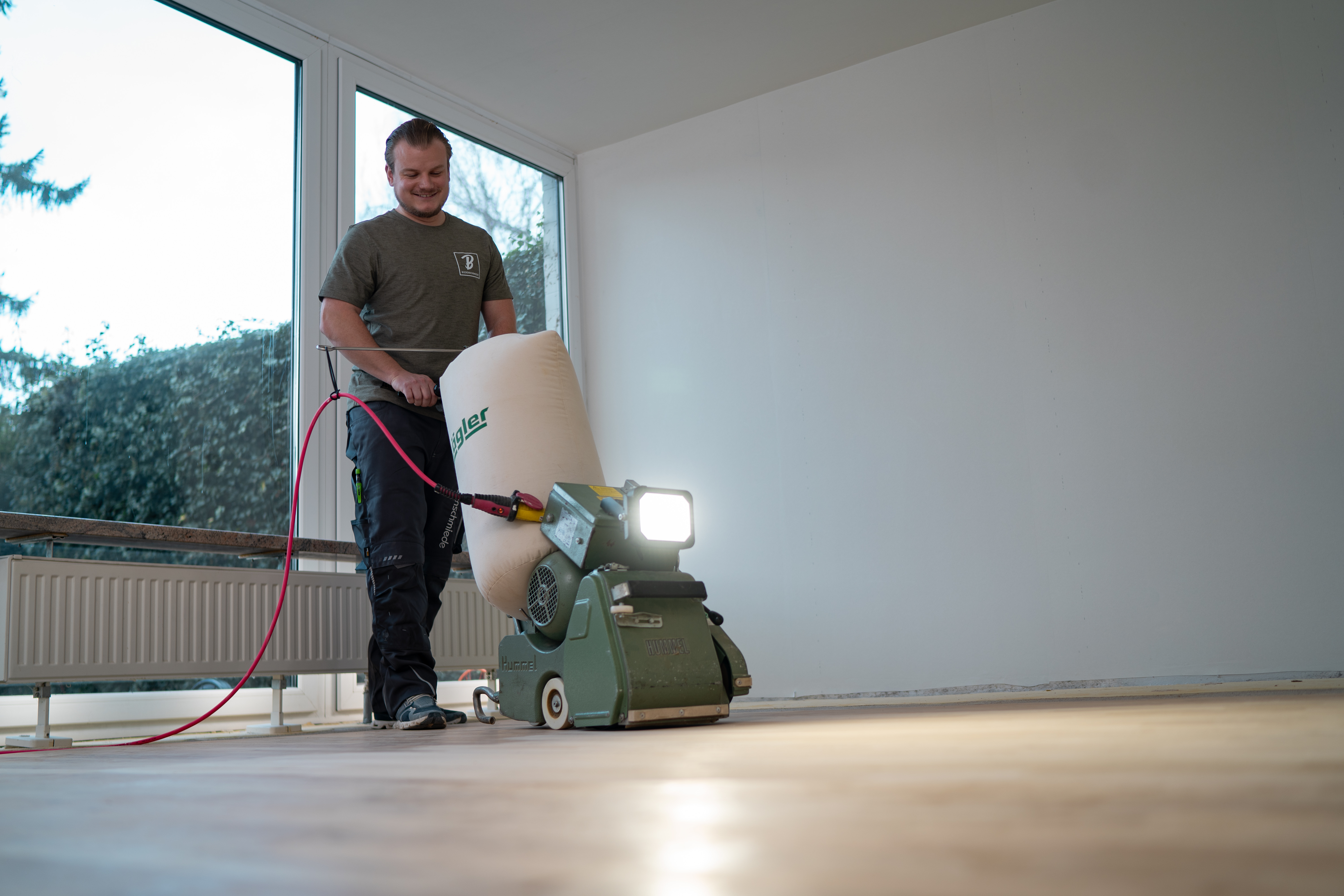 Nils Harder schleift Dielen mit Bodenschleifmaschine | Professionelle Bodenverlegung in Hamburg