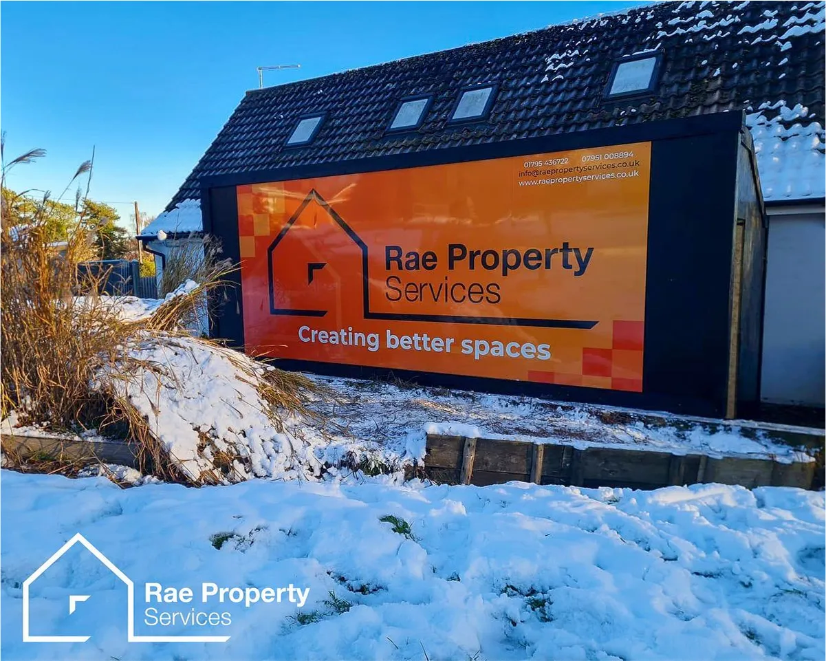 Rae Property Services sign on snowy ground with winter landscape