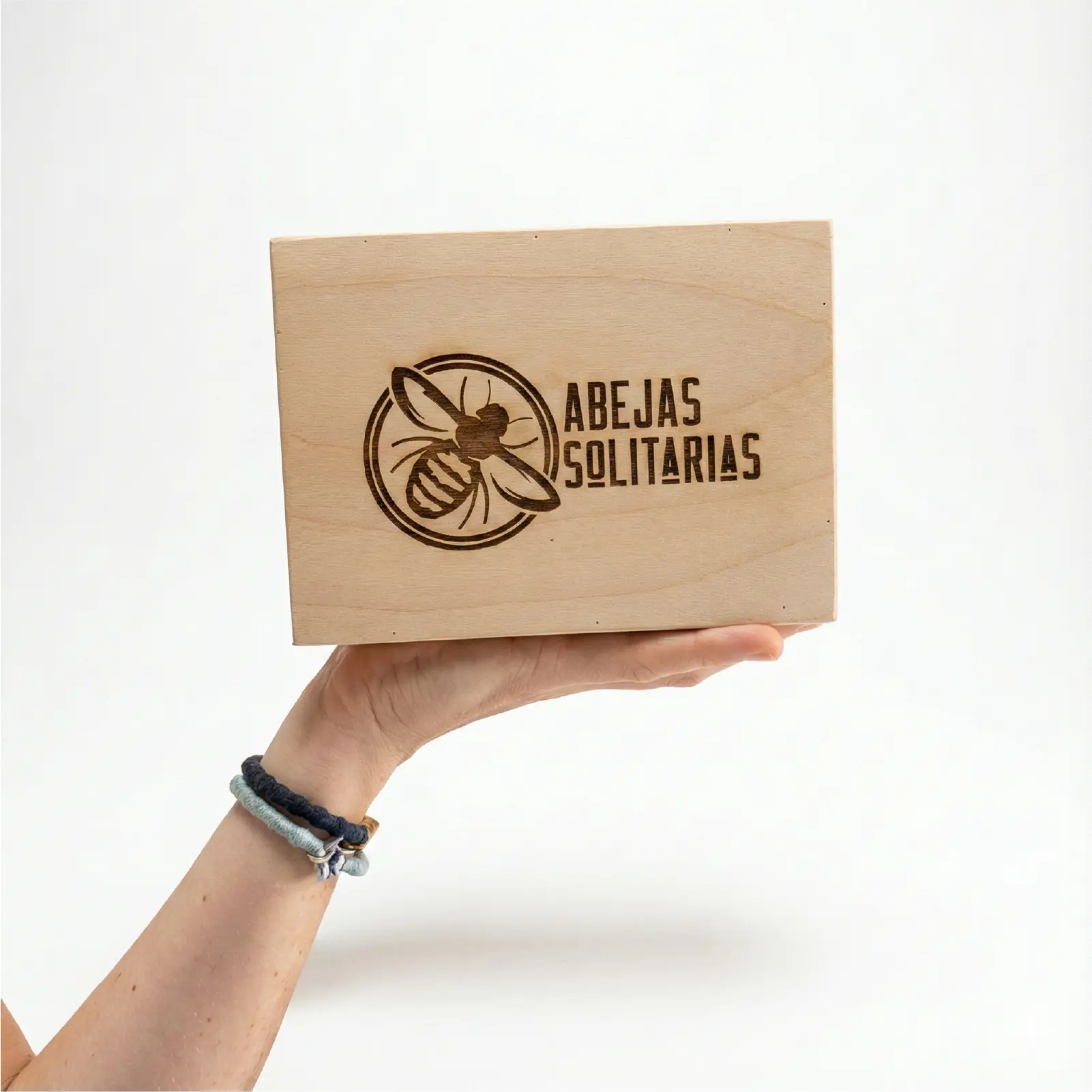 Persona sosteniendo el hotel para abejas en la mano, mostrando lo ligero y manejable que es este refugio para polinizadores.