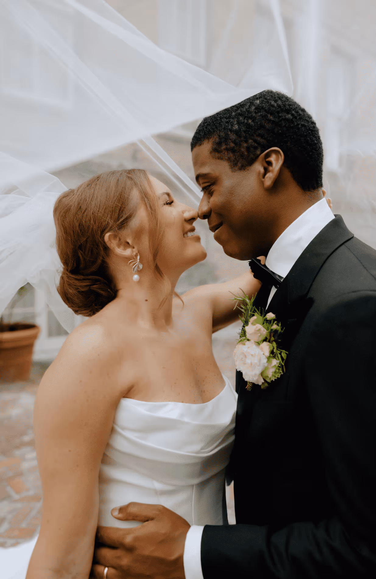 A pair of newlyweds smiling at each other.