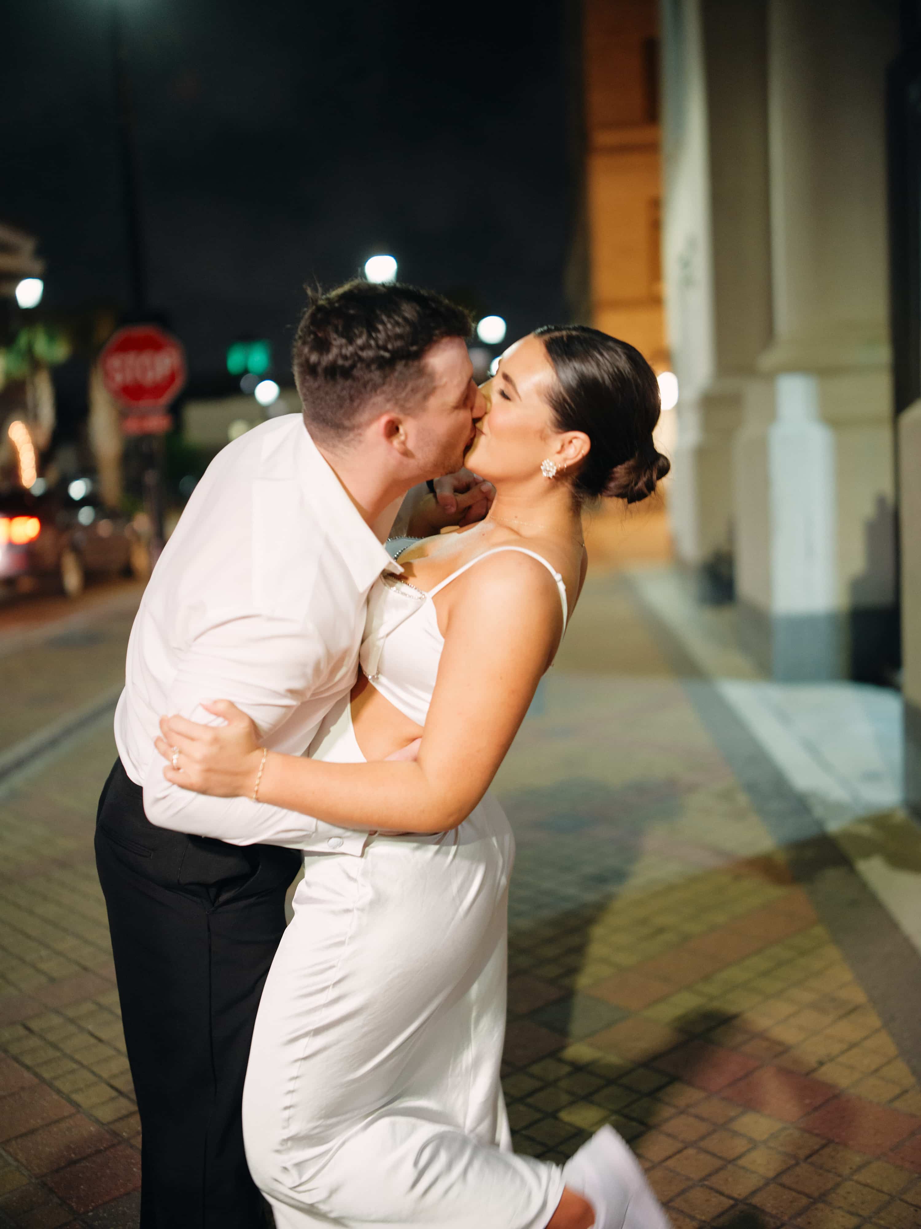 A joyful couple kissing in the street.