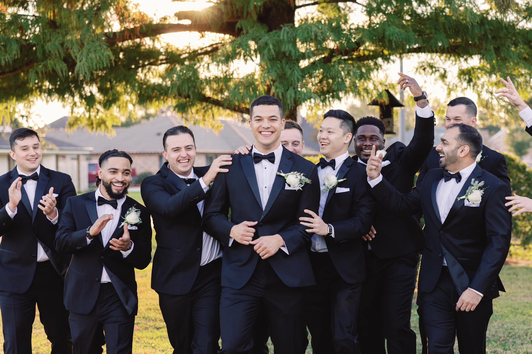 A groom and his groomsmen smiling and celebrating together.
