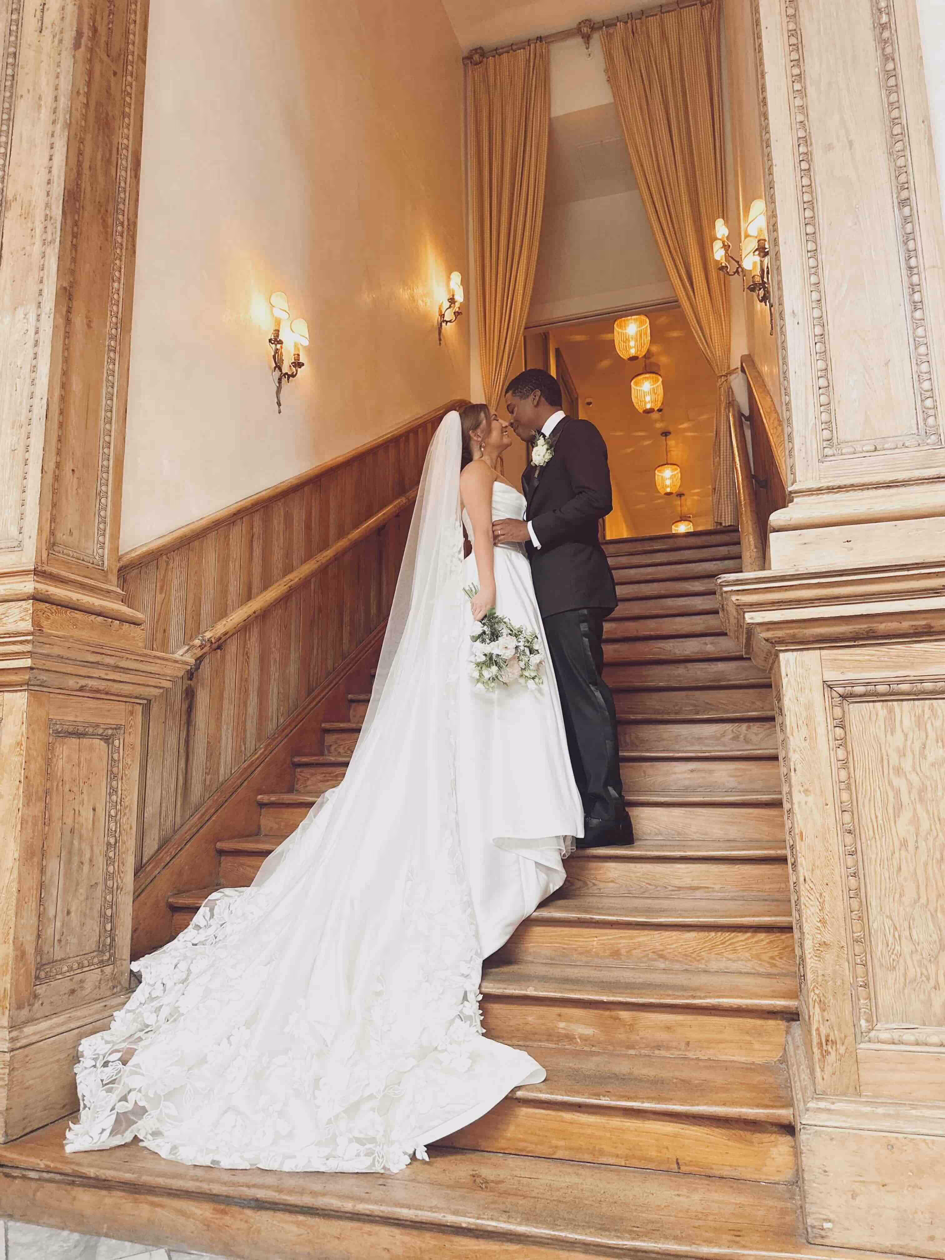 A bride and groom embracing on a beautiful staircase.