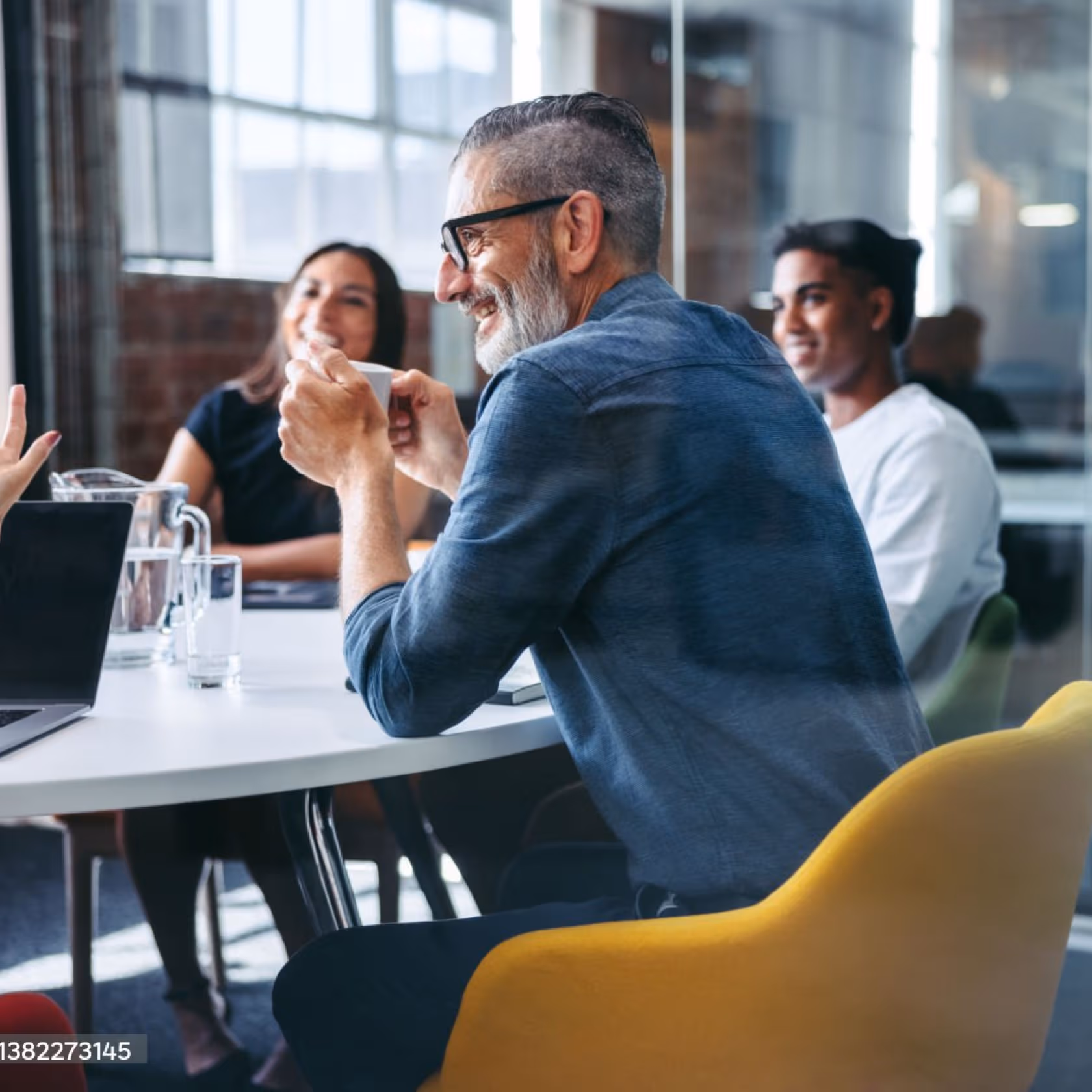 man talking to his team sitting on a yellow chair