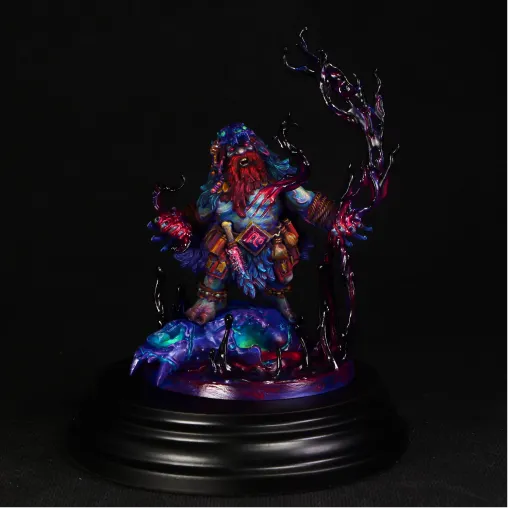 Colorful fantasy miniature figurine of a bearded warrior with red hair, blue armor, and glowing effects, holding a tall staff with dark swirling energy, standing on a detailed base with glowing elements, displayed on a black circular pedestal against a black background.