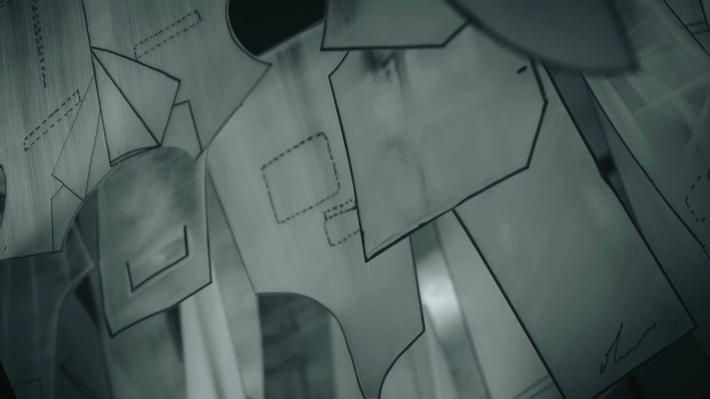 Close-up of translucent paper sewing patterns with outlines and markings spread on a wooden surface.