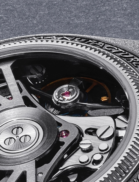 Close-up of a mechanical watch movement showing intricate gears, screws, and a ruby jewel bearing beneath a textured bezel.